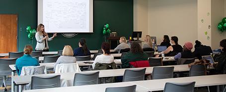 Inside Jefferson Hall, featuring a room with tables and chairs set up for a presentation on a whiteboard