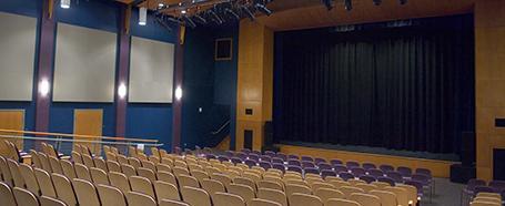 Inside Baker Theater, with tiered theater seats facing a stage