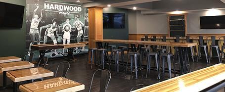 Inside Hardwood House restaurant, featuring tables and seating and bars and stools
