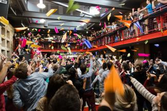a group of students throwing colorful paper airplanes