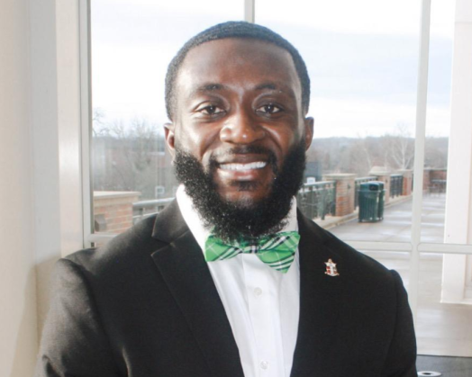 picture of andrew, young black male wearing a suit jacket and green bow tie