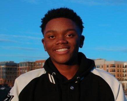 Picture of Eddy, young black male with dark hair wearing a black and white jacket