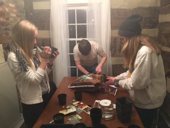 Students at a table labeling planting pots and prepping them with soil.