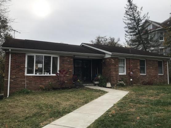 Brick ranch-style home with bay window, sidewalk through lawn to front door