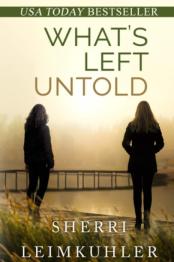 Two girls looking out over water with bridge in distance.