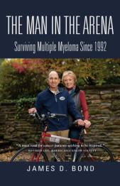 Man and woman standing together behind a bicycle smiling at camera.