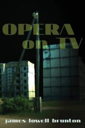 Tall buildings in background at night with wood pole in front.