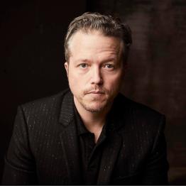 Jason Isbell headshot with black background