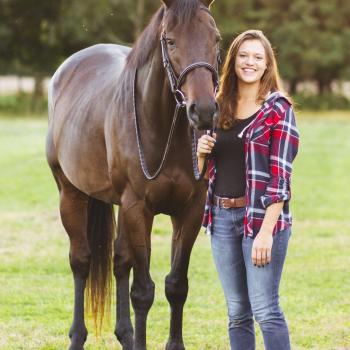 Becca Von Eiff stands with a horse in a green field