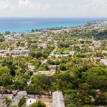 Overview of tree filled city with the coastline in the upper left corner. 