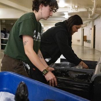 2 recycling employees changing bags of waste bins 