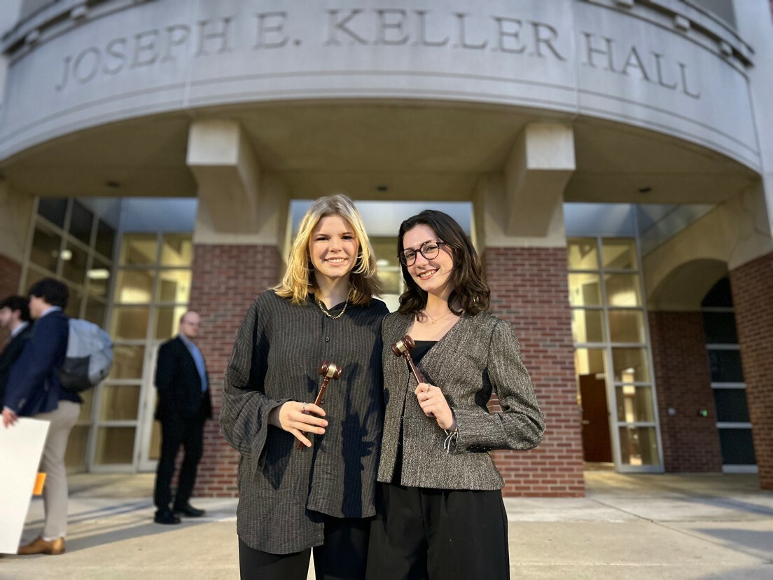 Ava Poling, left, and Katie Buschle, right, with their awards in front of the law school.