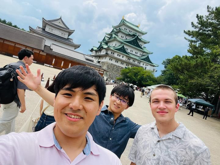 a selfie of nate and some friends with Nagoya castle in the background