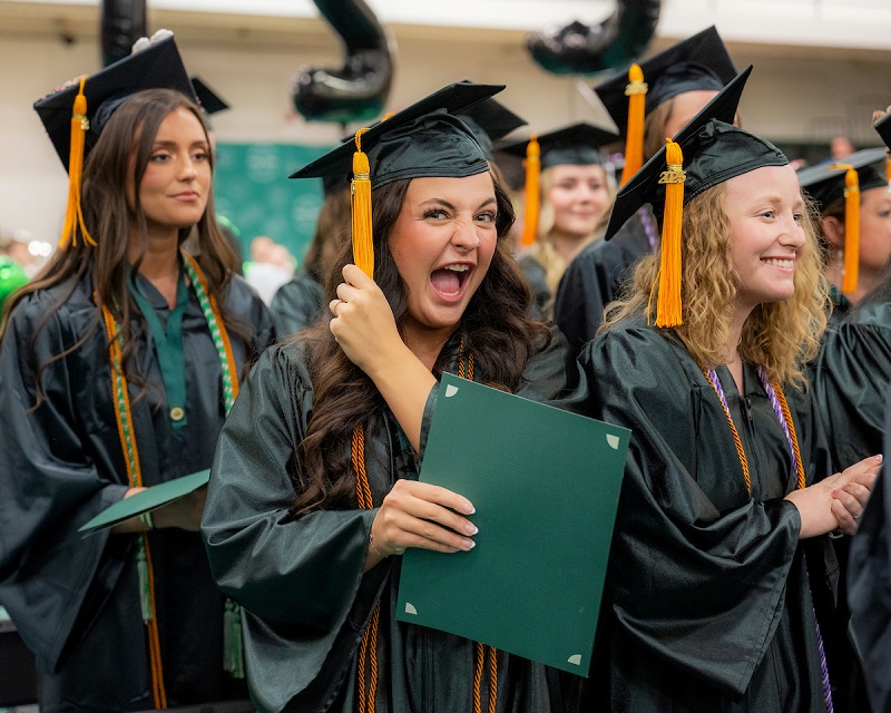 An OHIO graduate smiles and cheers at the OHIO Chillicothe Graduation Recognition Ceremony