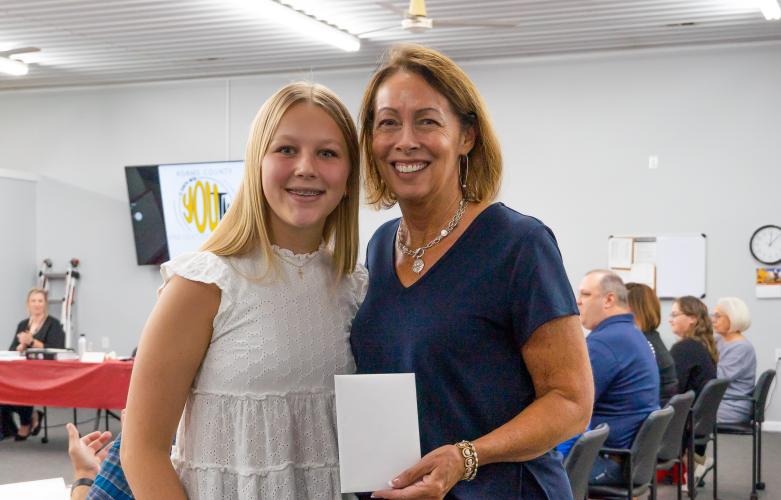 A woman poses with a teenager at an event