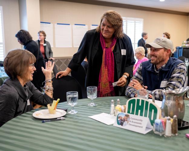 OHIO community members speak together while gathered around a table at the 社区参与 Symposium