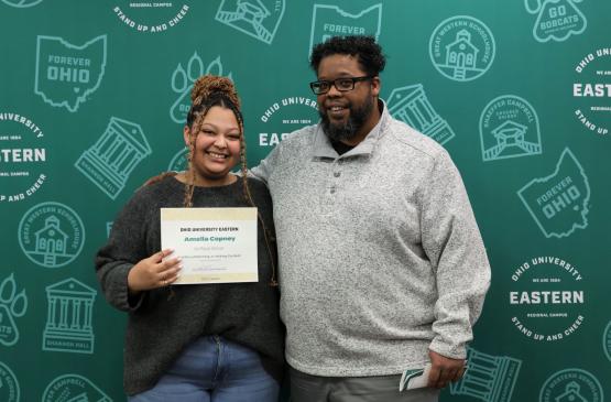 Female student holding certificate next to local chapter NAACP President