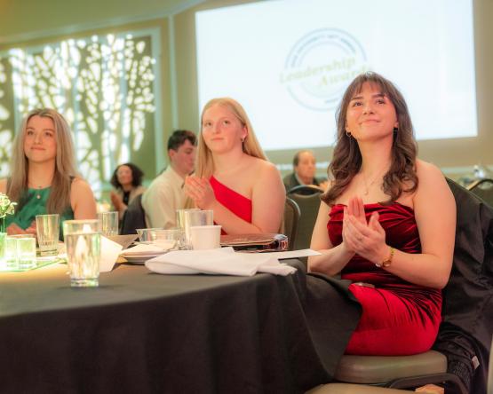 OHIO Student Trustee Ava Wood and two other OHIO students applaud an award winner at the 2025 Leadership Awards event