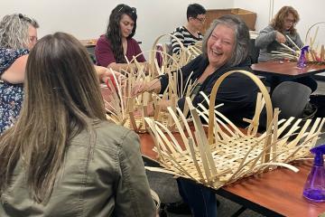 instructor laughs while teaching basket-weaving class