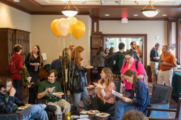 A party celebrating ONCA's anniversary, with several groups of people chatting
