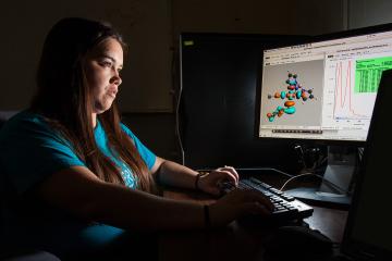 A chemistry student studying at a desktop computer. 