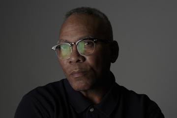a headshot of OHIO alumnus Milt Brown, wearing a black shirt and glasses