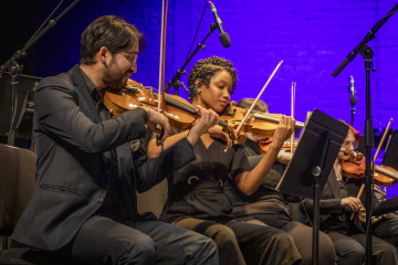 Row of musicians in black playing instruments