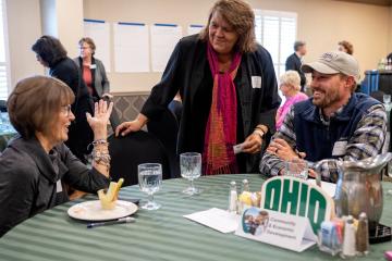 OHIO community members speak together while gathered around a table at the 社区参与 Symposium
