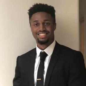 Jalen Warren wears a suit and smiles at the camera