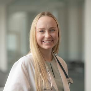Rosemary Oaks smiles and wears a doctor's coat and stethoscope.