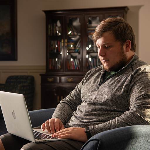 A student works on a laptop.