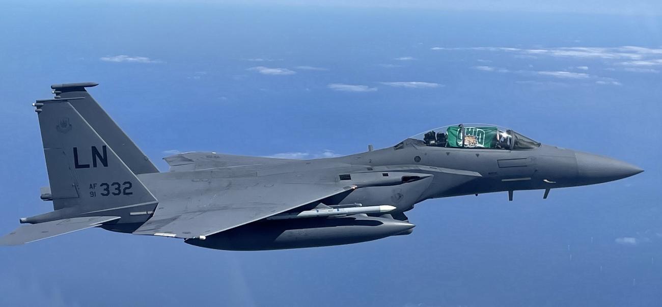 An Air Force plane flying with an Ohio University flag in the window