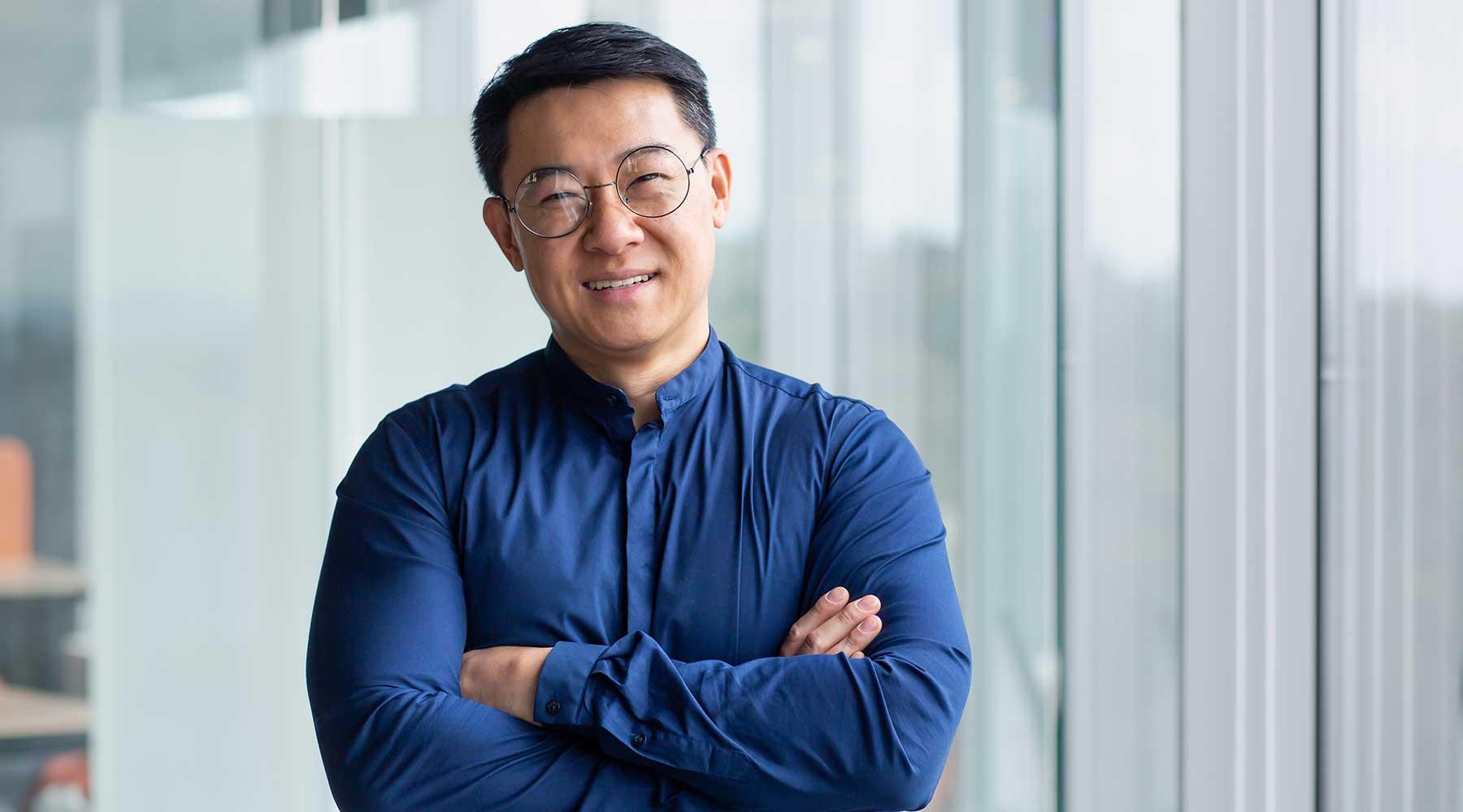 Smiling mpa in front of wall of windows