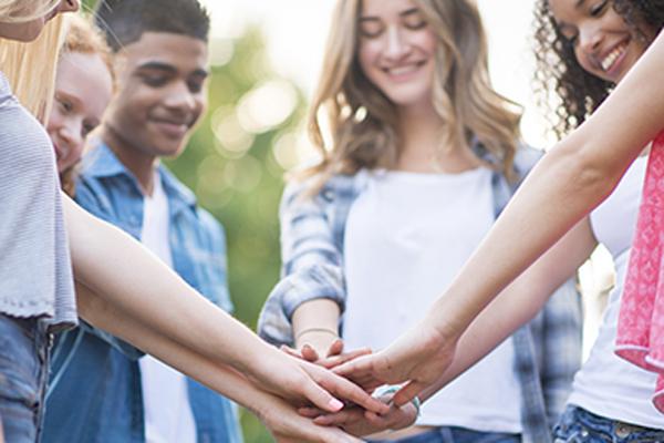 Schoolchildren with hands meeting in the middle